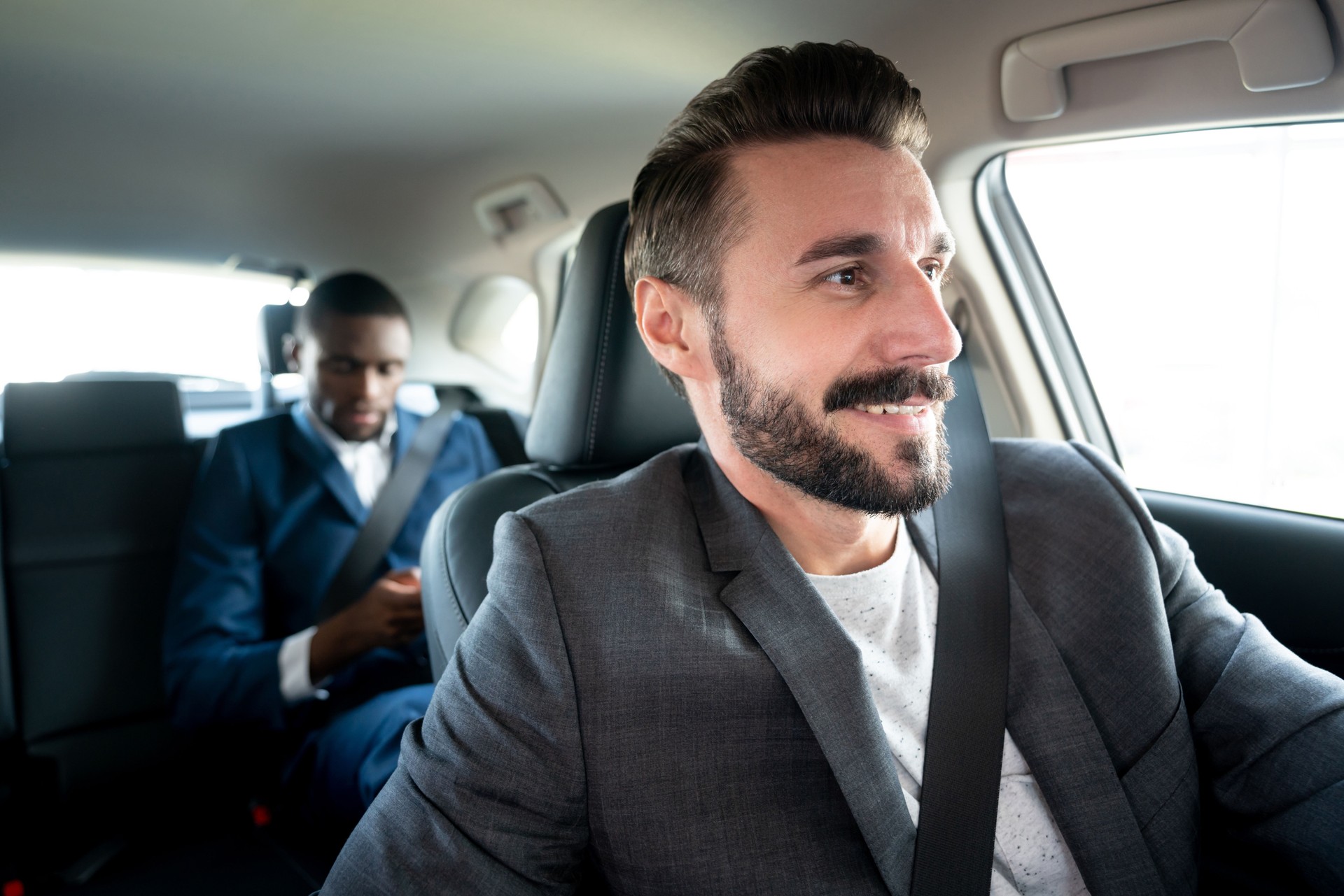 Man driving a businessman in a car