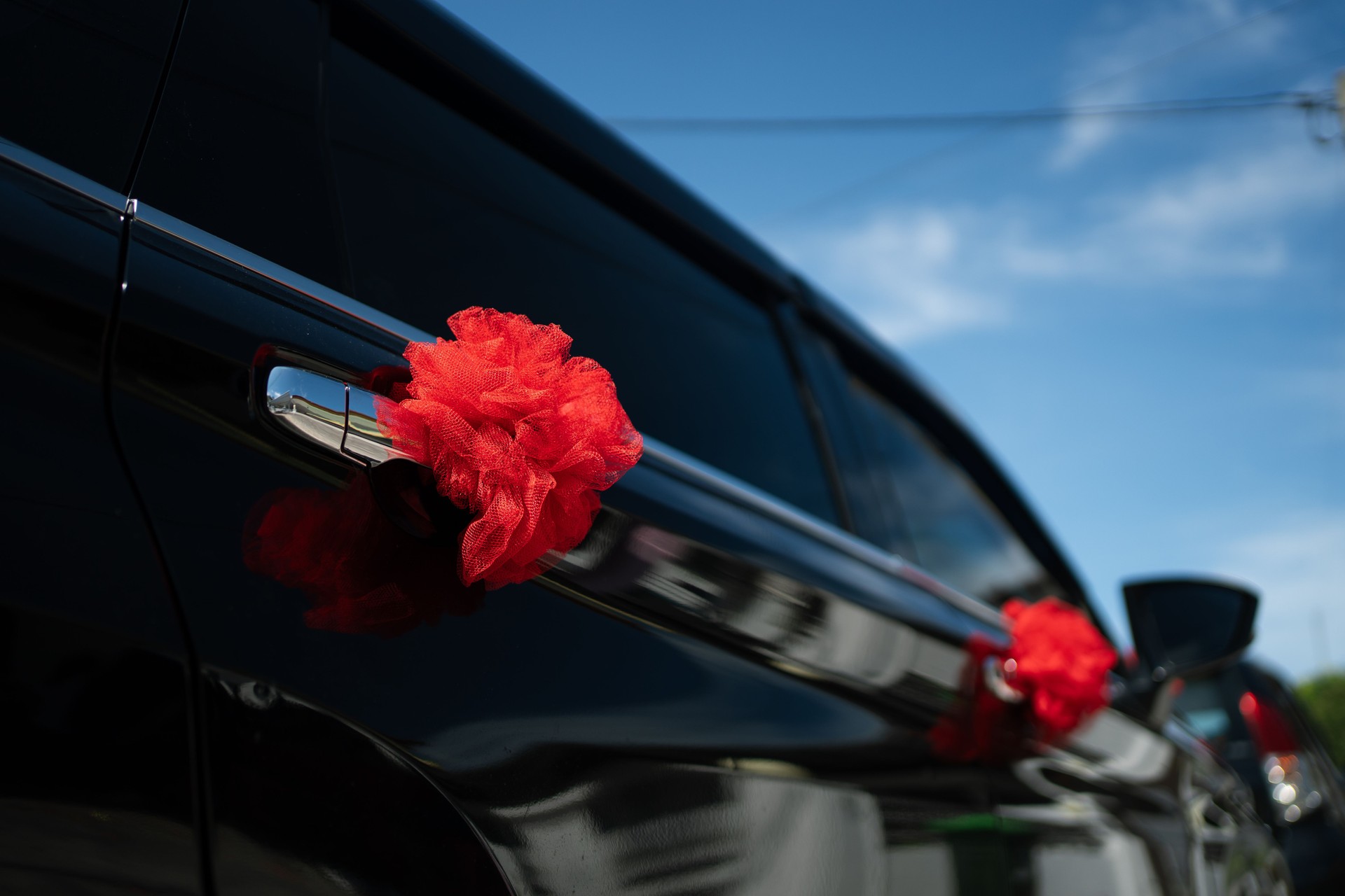 Black wedding car decorated with red ribbons. Chinese traditional wedding.